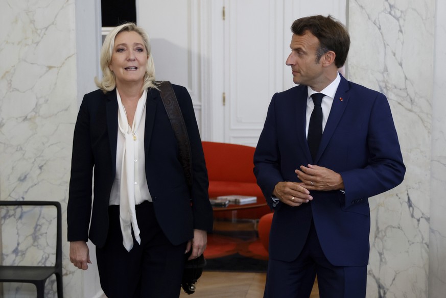 French President Emmanuel Macron, right, meets French far-right Rassemblement National (RN) leader and Member of Parliament Marine Le Pen at the Elysee Palace in Paris, France, Tuesday, June 21, 2022. ...
