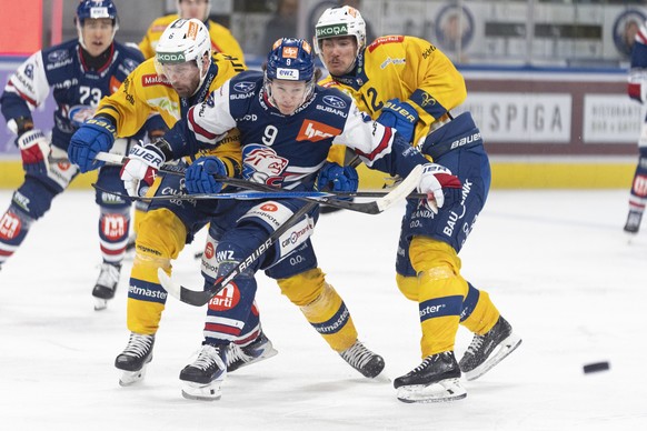 Vinzenz Rohrer (ZSC) Mitte kaempft um den Puck gegen Klas Dahlbeck (HCD) ,links und HC Davos, HCD,12 ,rechts, beim Eishockeyspiel der National League ZSC Lions gegen den HC Davos in der Swiss Life Are ...