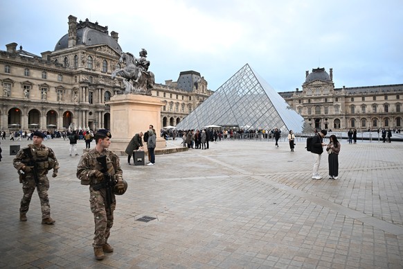 Soldiers patrol as people queue to enter the Louvre museum that remains closed for the day after Sunday's jewels robbery, Monday, Oct. 20, 2025 in Paris. (AP Photo/Emma Da Silva)
France Louvre