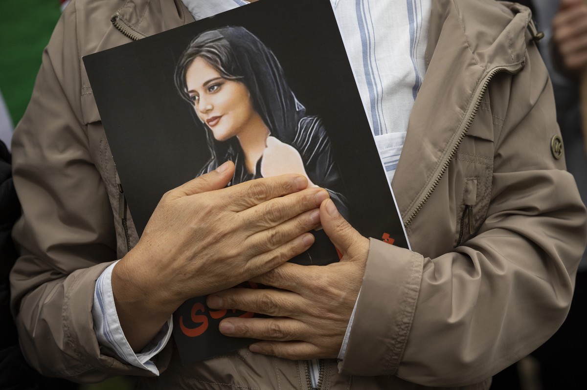 FILE - A portrait of Mahsa Amini is held during a rally calling for regime change in Iran following the death of Amini, a young woman who died after being arrested in Tehran by Iran's notorious & ...