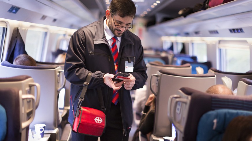 ZUR EINFUEHRUNG DES SWISSPASSES VOR DREI MONATEN STELLEN WIR IHNEN HEUTE, MITTWOCH, 4. NOVEMBER 2015, FOLGENDES NEUES BILDMATERIAL ZUR VERFUEGUNG --- Conductor Salvatore Grade verifies a train passeng ...