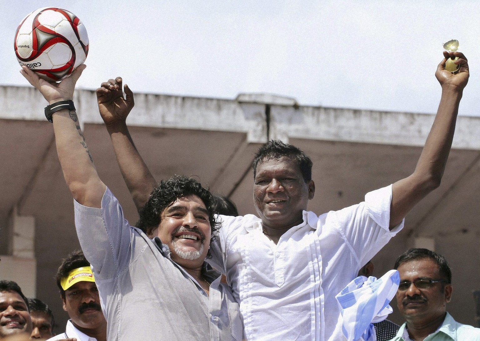 In this Wednesday, Oct. 24, 2012 photo, Argentina soccer legend Diego Maradona, left, and Indian football player I.M.Vijayan acknowledge the crowd, unseen, in Kannur, Kerala, India. Maradona enthralle ...
