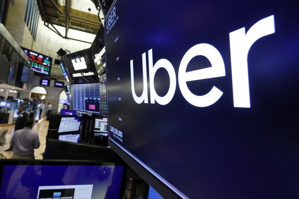 FILE - The logo for Uber appears above a trading post on the floor of the New York Stock Exchange, Friday, Aug. 9, 2019. Uber���s ride-hailing service continued to gain momentum in the second quarter  ...