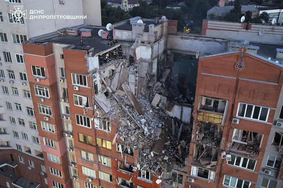 epa11444291 A handout picture made available by the State Emergency Service shows Ukrainian rescuers working at the site of a rocket strike on a residential building in the city of Dnipro, Ukraine, 29 ...