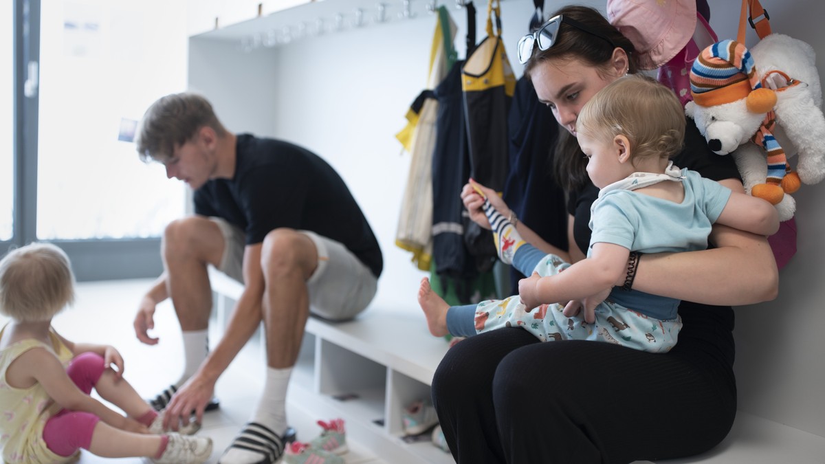 THEMENBILD ZUR LANCIERUNG DER KITA-INITIATIVE --- Betreuungspersonal hilft Kleinkindern beim Anziehen der Schuhe und Sonnenschutzkleidung, bevor es zum Spielen in den Aussenbereich der Kita 6a der Sti ...