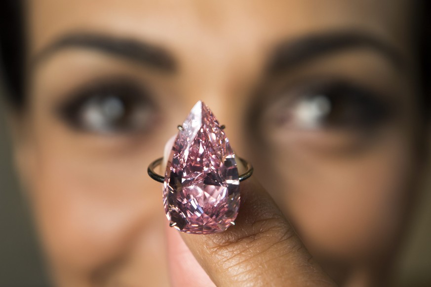 epa05296262 A model displays &#039;The Unique Pink&#039;, the largest vivid pink pear shaped diamond ever offered at auction, during a Sotheby&#039;s press preview in Geneva, Switzerland, 09 May 2016. ...