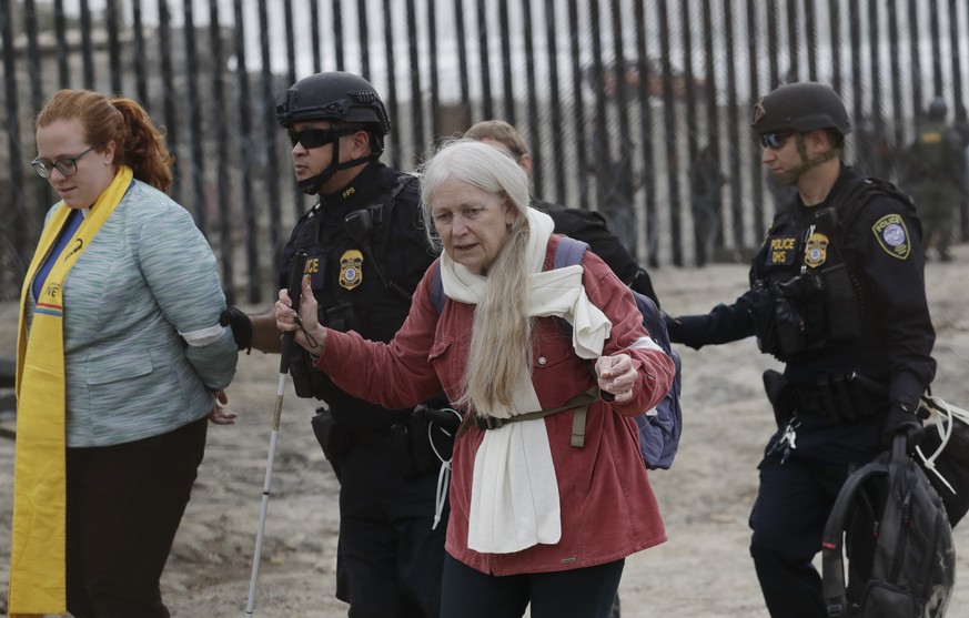 Women are detained during a protest near the border with Tijuana, Mexico, Monday, Dec. 10, 2018, in San Diego. U.S. Border Patrol agents have handcuffed more than a dozen people participating in a dem ...