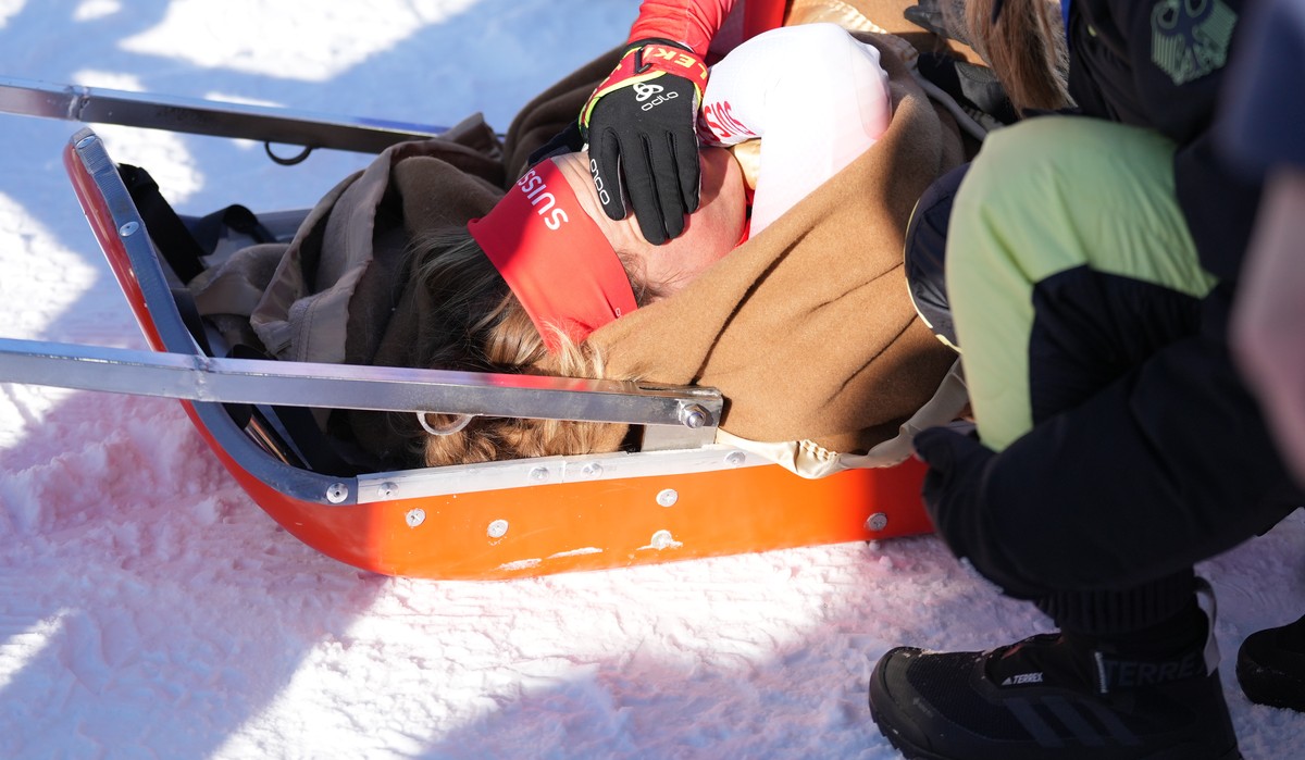 epa09761336 Irene Cadurish of Switzerland receives medical attention during the Women's Biathlon 4x6km Relay race at the Zhangjiakou National Biathlon Centre at the Beijing 2022 Olympic Games, Zh ...