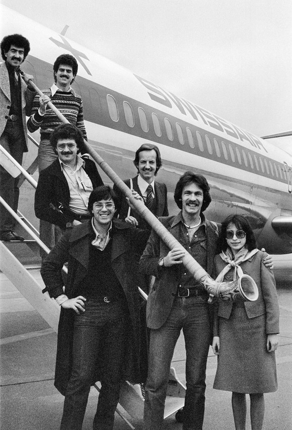Der Schweizer Bandleader Pepe Lienhard, 2.v.r., mit seiner Band und dem, im Stueck "Swiss Lady" besungenen Alphorn, vor dem Abflug am 3. Mai 1977 auf dem Flughafen Zuerich-Kloten nach London ...
