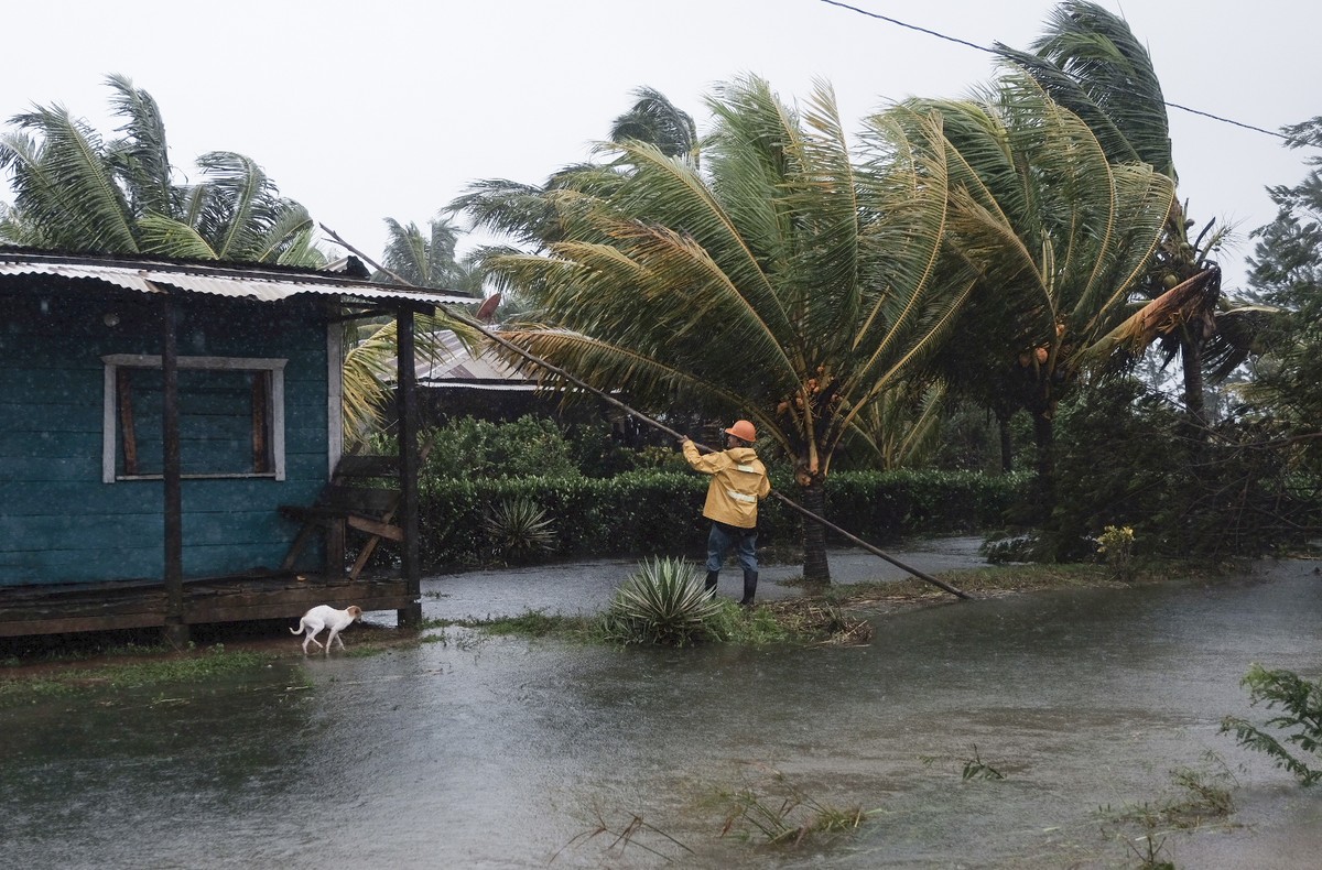A man fixes the roof of a home surrounded by floodwaters brought on by Hurricane Eta in Wawa, Nicaragua, Tuesday, Nov. 3, 2020. Eta slammed into Nicaragua's Caribbean coast with potentially devas ...