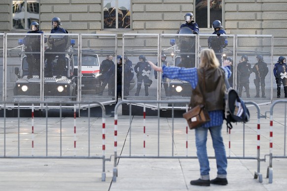 epa06435792 A protester stands in front of riot police during a demonstration against the World Economic Forum (WEF), in Bern, Switzerland, 13 January 2018. The WEF will take place from January 23 til ...