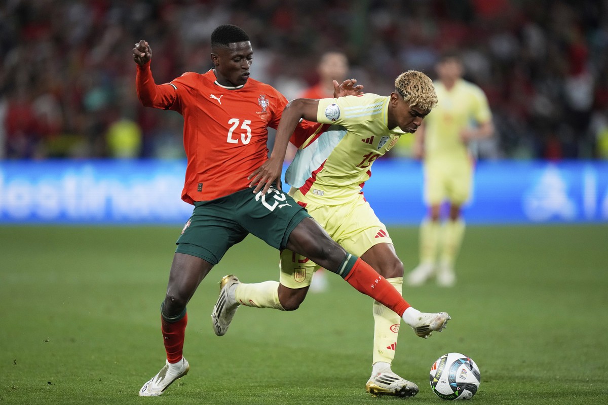 Portugal's Nuno Mendes, left, challenges Spain's Lamine Yamal during the Nations League final soccer match between Portugal and Spain at the Allianz Arena in Munich, Germany, Sunday, June 8, ...