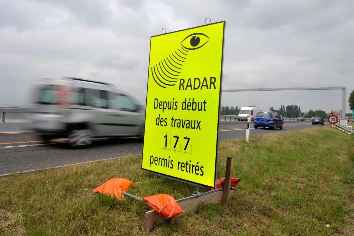 Des vehicules passent devant un panneau de la Police cantonale Vaudoise signalant le nombre de permis de conduire retire pour exces de vitesse dans la zone de travaux sur l'autoroute A1 entre Lau ...