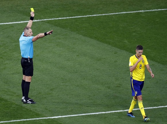 Referee Nestor Pitana from Argentina, left, shows a yellow card to Sweden&#039;s Mikael Lustig during the group F match between Mexico and Sweden, at the 2018 soccer World Cup in the Yekaterinburg Are ...