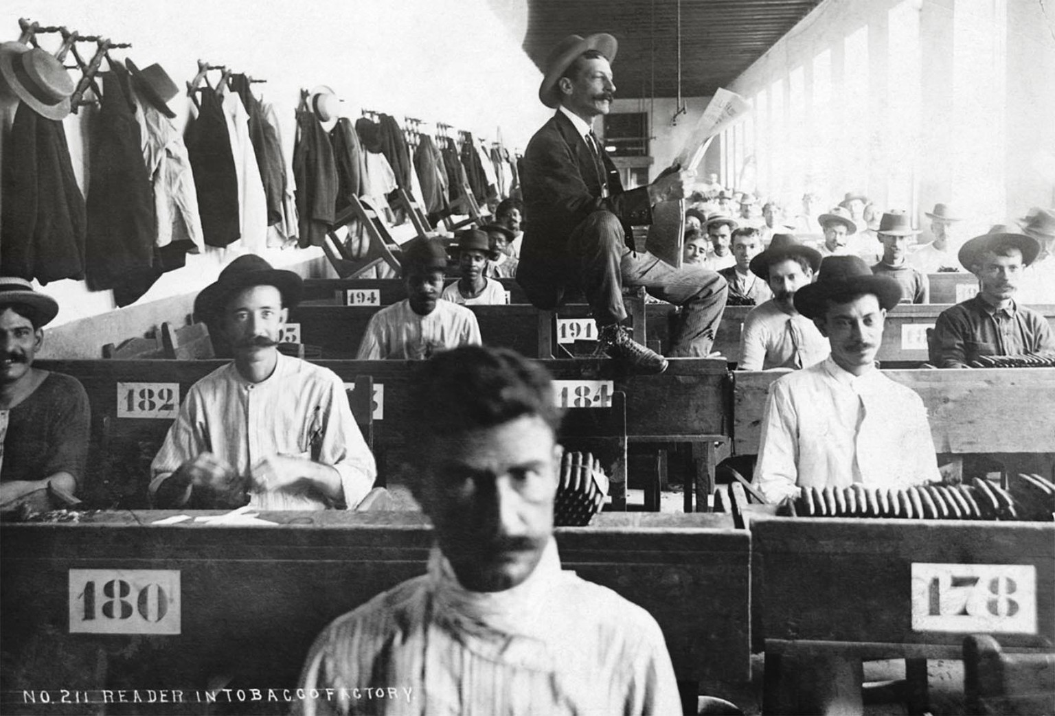 Ein Fabrik-Lektor liest den Zigarrenmachern einer kubanischen Fabrik die Zeitung vor, zwischen 1900 und 1910.