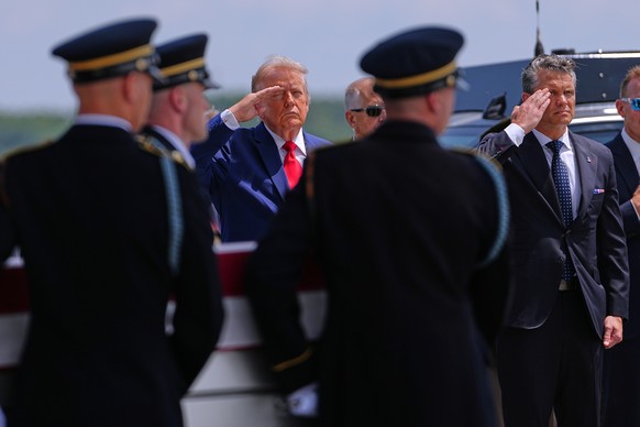 President Donald Trump and Secretary of Defense Pete Hegseth salute as a U.S. Army carry team moves a transfer case containing the remains of Sgt. Angel S. Rampersad, of Ozone Park, N.Y. Wednesday, Ju ...