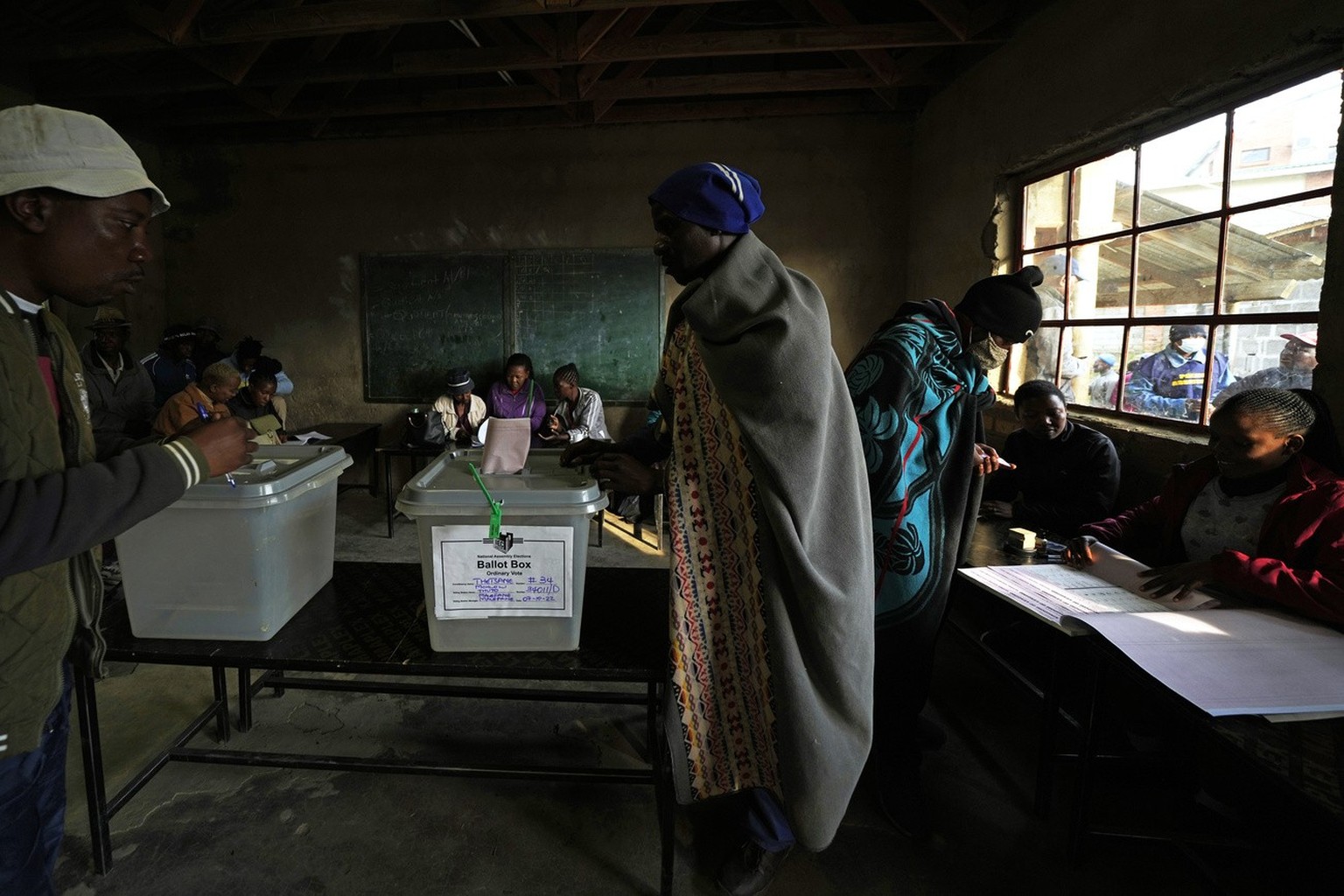 A man wearing a blanket cast his vote at a poling station in Maseru, South Africa, Friday, Oct. 7, 2022. Voters across Lesotho are heading to the polls Friday to elect a leader to find solutions to hi ...