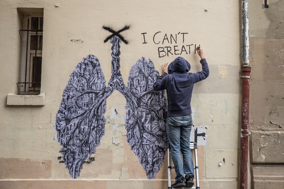 epaselect epa08473308 Ardif, a 33 years old French street-artist, works on the paste-up of a graffito at a wall of a building in Rue Oberkampf, in Paris, France, 08 June 2020. Ardif&#039;s graffito de ...