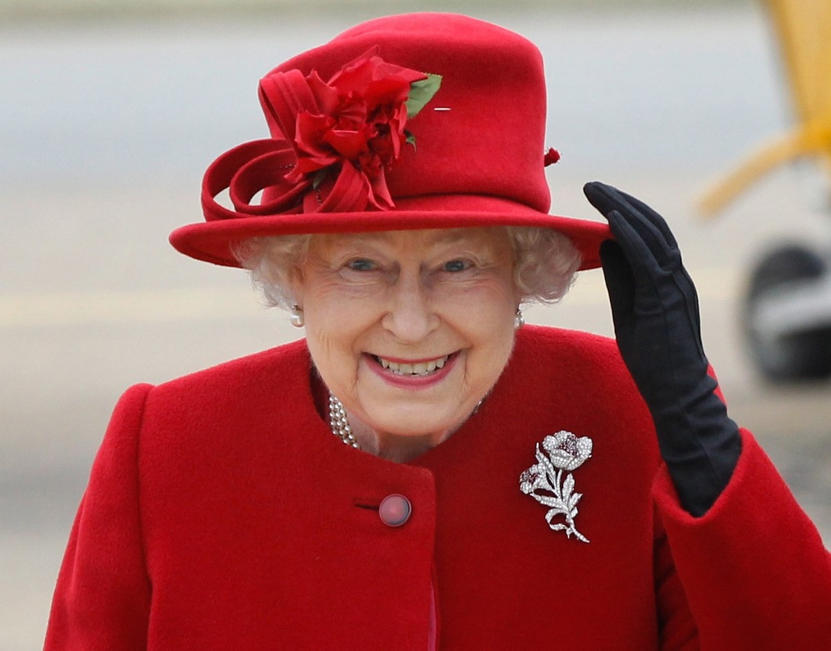 Britain's Queen Elizabeth II holds on to her hat in high winds as she arrives for a visit to RAF Valley, Anglesey, Wales, where her grandson Prince William, is stationed as a search and rescue he ...