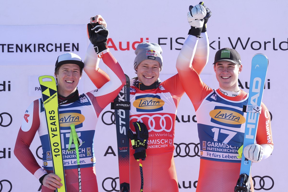 From left, second placed Austria's Raphael Haaser, the winner Switzerland's Marco Odermatt and third placed Switzerland's Franjo von Allmen celebrate after an alpine ski, men's Wor ...