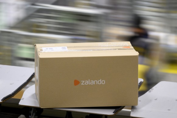 Un paquet &quot;Zalando&quot; est transporte sur un tapis roulant au centre colis de La Poste ce jeudi 15 decembre 2022 a Daillens, Vaud. Pendant les jours de pointe avant Noel, le volume depasse souv ...