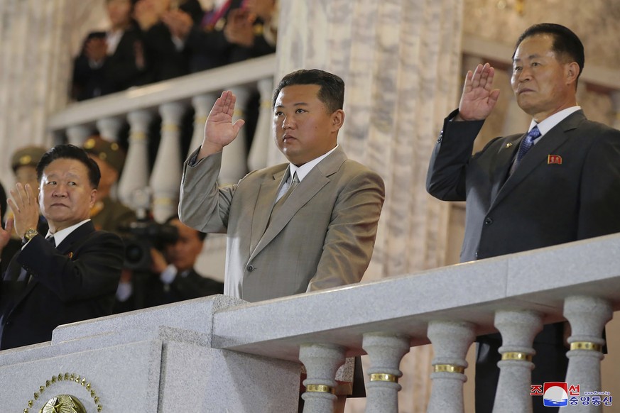 In this photo provided by the North Korean government, North Korean leader Kim Jong Un, center, waves from a balcony toward the assembled troops and spectators during a celebration of the nation���s 7 ...