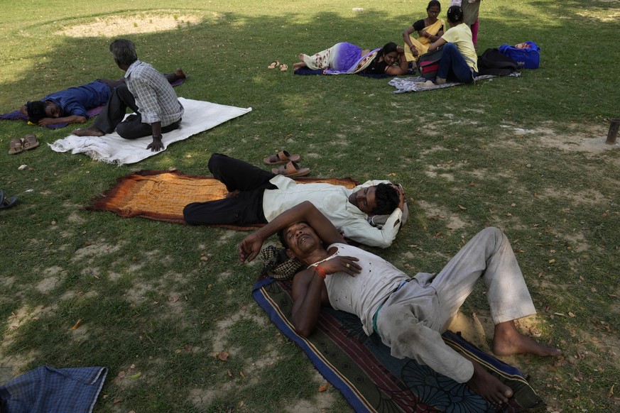 People rest in the shade of a tree on a hot summer afternoon in Lucknow in the central Indian state of Uttar Pradesh, Thursday, April 28, 2022. Severe heat wave conditions are sweeping north and weste ...
