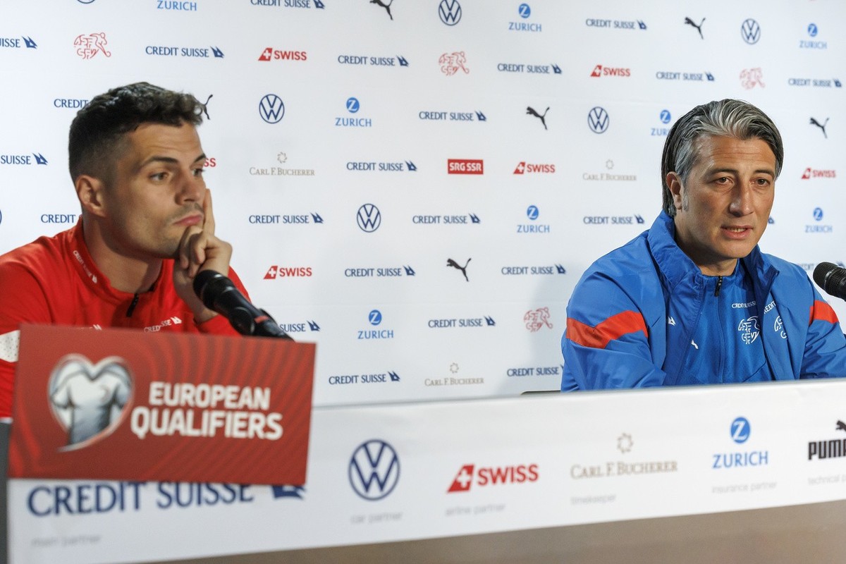 Switzerland's head coach Murat Yakin, right, sitting next to Switzerland's midfielder Granit Xhaka, left, speaks to the media, during a press conference of the national soccer team Switzerla ...
