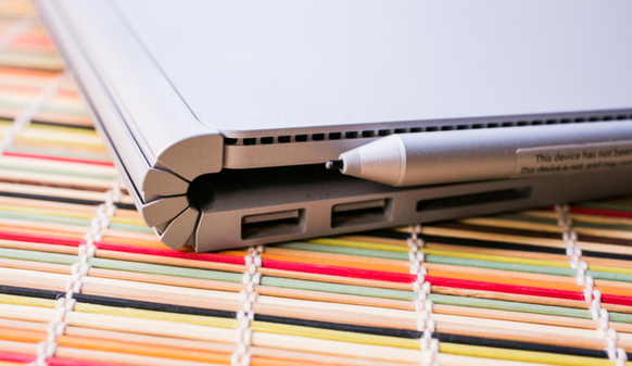 Der Stift haftet magnetisch am Tablet, sprich am Display des Laptops.