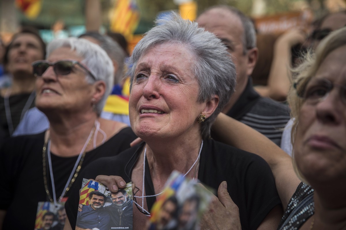People react as they watch the parliament session on a huge screen during a rally outside the Catalan parliament in Barcelona, Spain, Friday, Oct. 27, 2017. Catalonia's regional parliament has pa ...