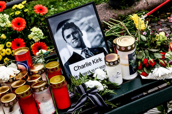 epa12373904 Flowers and candles are placed in front of a photo of the slain US political activist Charlie Kirk during a vigil in reaction to his assassination, in Berlin, Germany, 13 September 2025. K ...