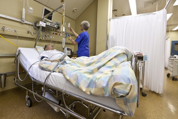 Eine Pflegefachfrau kontrolliert die Infusion eines Patienten auf der Intensivstation in einem Spital in Ilanz.