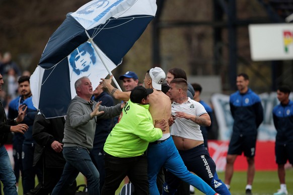 epa07828749 A fan is taken out of the field during Diego Maradona's first training session as coach of Gimnasia y Esgrima La Plata, in an open-door event for club members at the Juan Carmelo Zeri ...