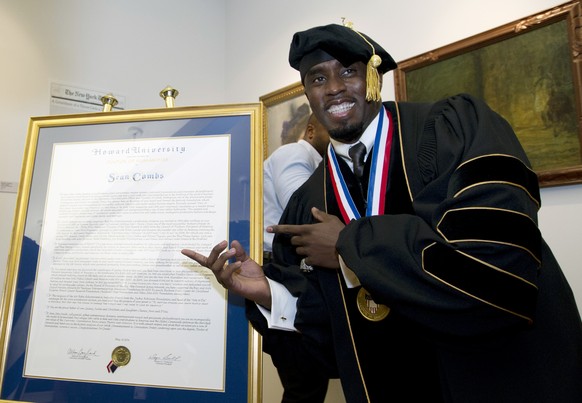 FILE - Entertainer and entrepreneur Sean Combs poses next to his honorary degree of Doctor of Humanities during the graduation ceremony at Howard University in Washington, Saturday, May 10, 2014. In a ...