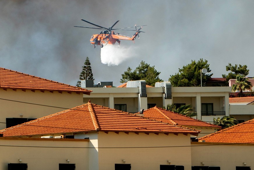 Clouds of smoke from a forest fire rise to the sky on the island of Rhodes, Greece, Saturday, July 22, 2023. A large blaze burning on the Greek island of Rhodes for the fifth day has forced authoritie ...