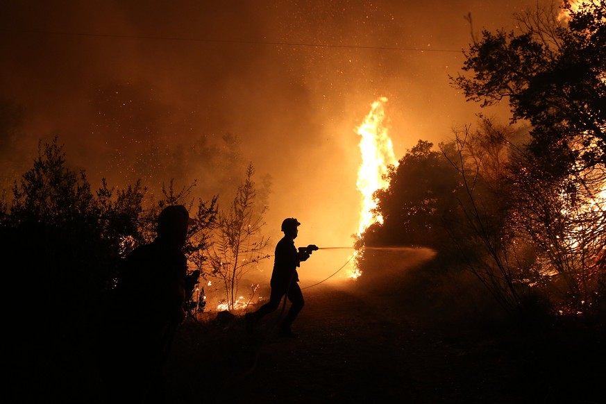 epa06143204 A fireman tries to extinguish a wildfire near Kalamos village, 50 km north of Athens, Greece, 13 August 2017. More than 40 firefighters with 20 fire engines and three aircraft were deploye ...