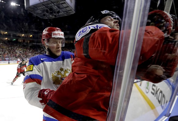 Russia&#039;s Sergei Andronov, left, checks Canada&#039;s Josh Morrissey at the Ice Hockey World Championships semifinal match between Canada and Russia in the LANXESS arena in Cologne, Germany, Satur ...