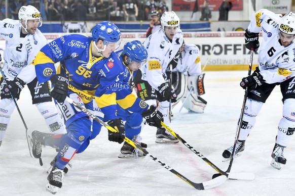 Chris Egli und Tino Kessler von Davos, gegen Mathieu Maret und Christopher Rivera von Fribourg, von links, beim Eishockey-Qualifikationsspiel der National League A zwischen dem HC Davos und dem HC Fri ...