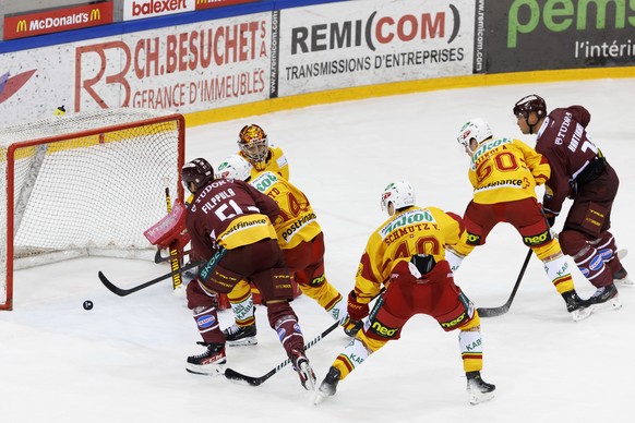 Geneve-Servette&#039;s forward Teemu Hartikainen, right, scores the winner goal against Tigers&#039; goaltender Stephane Charlin, during the overtime of the National League regular season game of the  ...