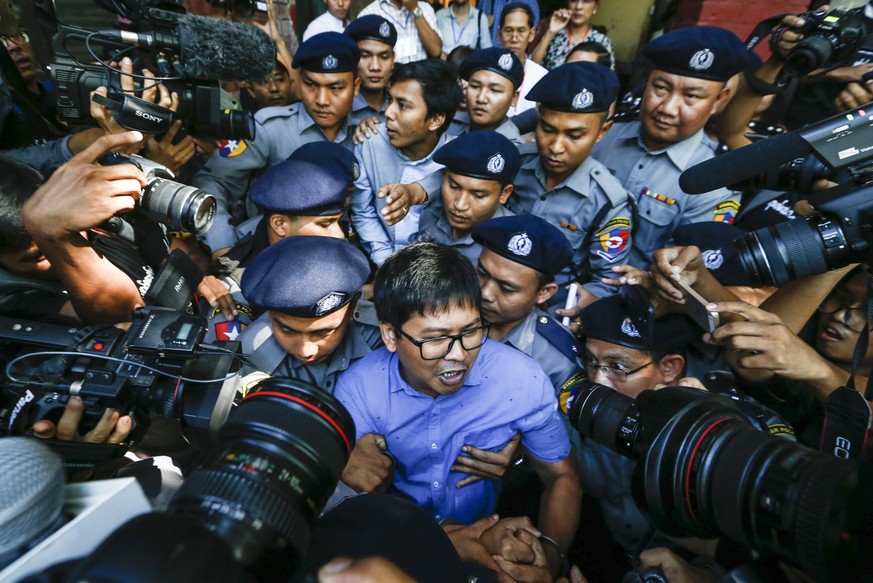 epa07078143 Reuters&#039; journalists Wa Lone (C, front) and Kyaw Soe Oo (C, back) are escorted by police as they leave the court after their first trial in Yangon, Myanmar, 10 January 2018. Reuters j ...