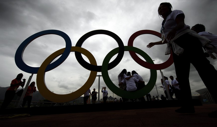 epa05453239 People pose for photos in front of Olympic Rings at the Barra Olympic Park prior to the Rio 2016 Olympic Games in Rio de Janeiro, Brazil, 02 August 2016. The Rio 2016 Olympic Games will ta ...