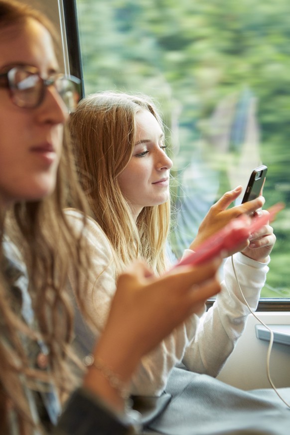 ZUM THEMA JUGENDLICHE UND MOBILTELEFON STELLEN WIR IHNEN HEUTE, DONNERSTAG, 14.01.2016, FOLGENDES BILDMATERIAL ZUR VERFUEGUNG --- Female adolescents use their smart phones while commuting in the city  ...