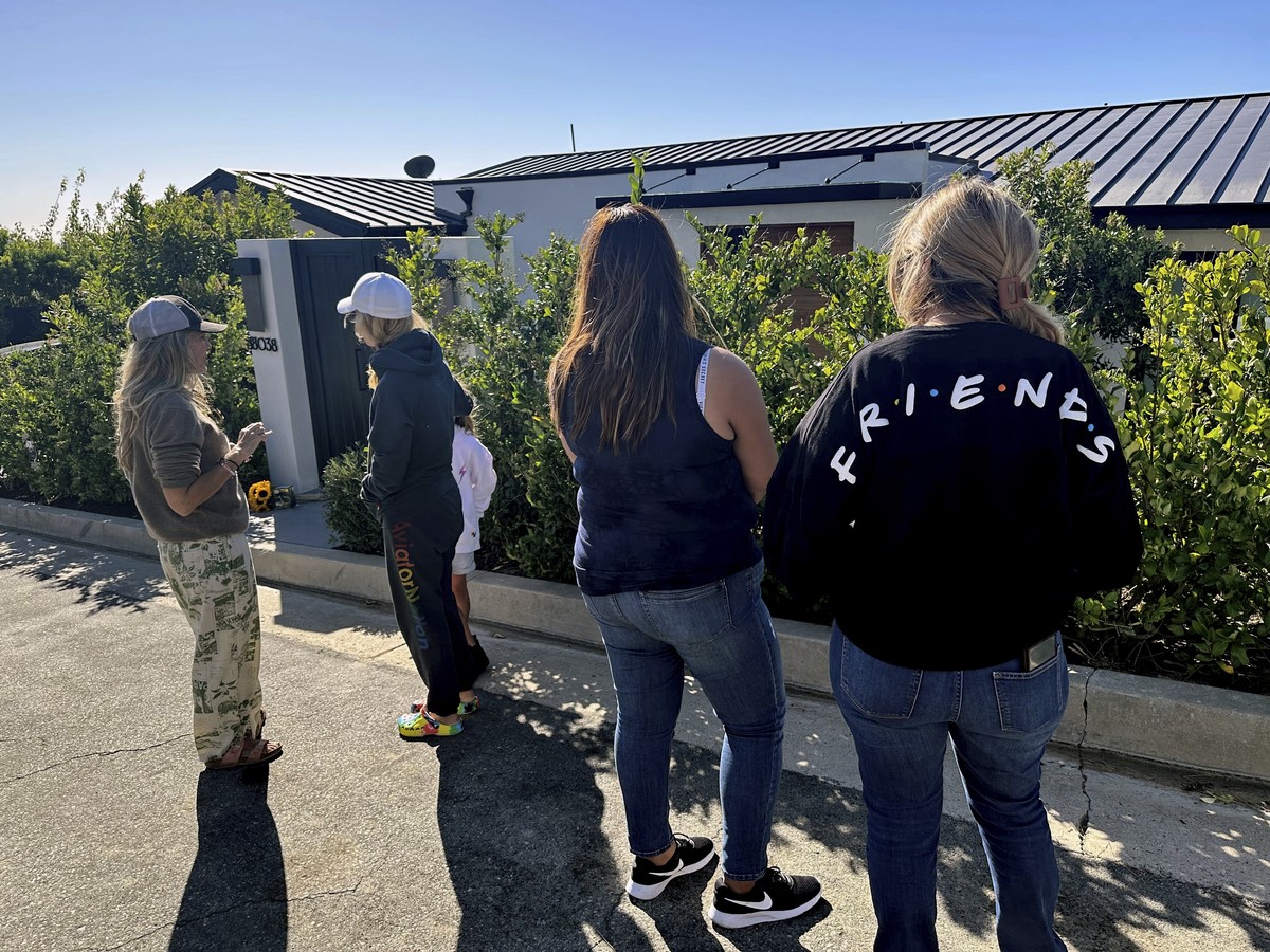 Mourners stand outside the home of actor Matthew Perry, Sunday, Oct. 29, 2023, in the Pacific Palisades area of Los Angeles. Perry, who starred as Chandler Bing in the hit series "Friends,"  ...