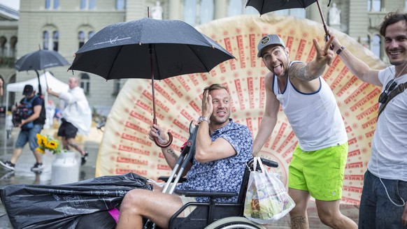 Die Cabaretisten Divertimento Jonny Fischer, links, und Manuel Burkart, amuesieren sich trotz Regen auf dem Bundesplatz am 1. August, der Bundesfeier, aufgenommen am Mittwoch, 1. August 2018, in Bern. ...