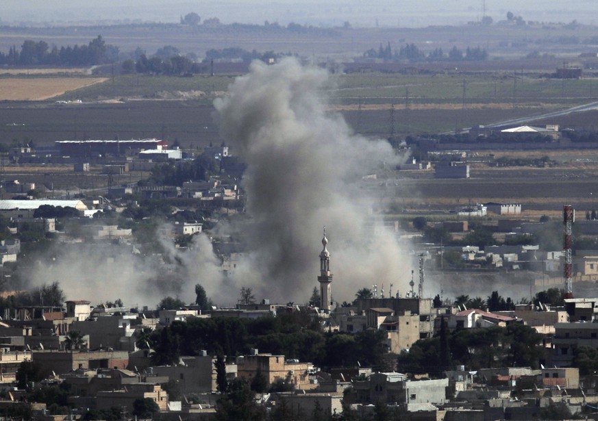 In this photo taken from the Turkish side of the border between Turkey and Syria, in Ceylanpinar, Sanliurfa province, southeastern Turkey, smoke and dust billows from targets in Ras al-Ayn, Syria, cau ...