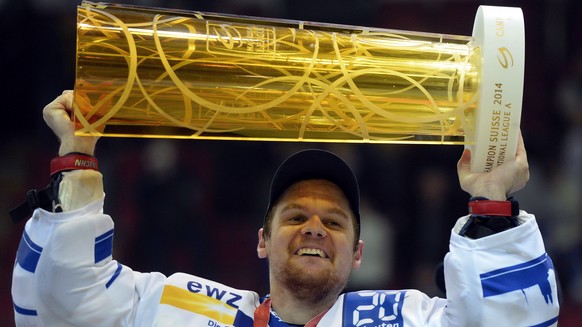 Der Zuercher Lukas Flueler mit dem Meisterpokal nach dem Sieg im vierten Playoff-Finalspiel der National League Kloten Flyers gegen die ZSC Lions und dem Gewinn des Schweizermeistertitels in Kloten am ...