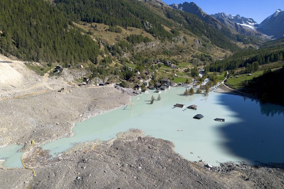 Destroyed and flooded houses are pictured during a groundbreaking ceremony of reconstruction of the devastated village of Blatten, Switzerland, Friday, Sept. 19, 2025, 3,5 months after a landslide des ...