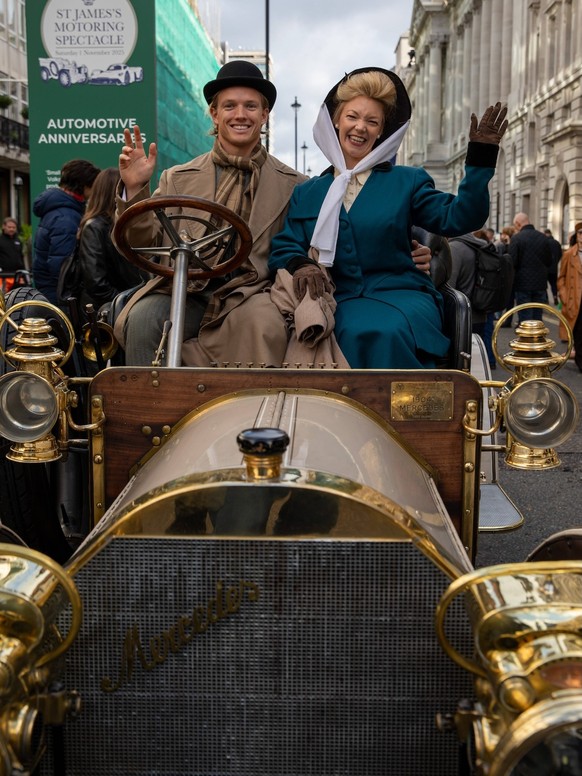 November 1, 2025, London, United Kingdom: A gentlemen a Lady wearing traditional driving clothes sit in a vintage car during a show. Thousands of people gathered on Pall Mall in Central London for the ...