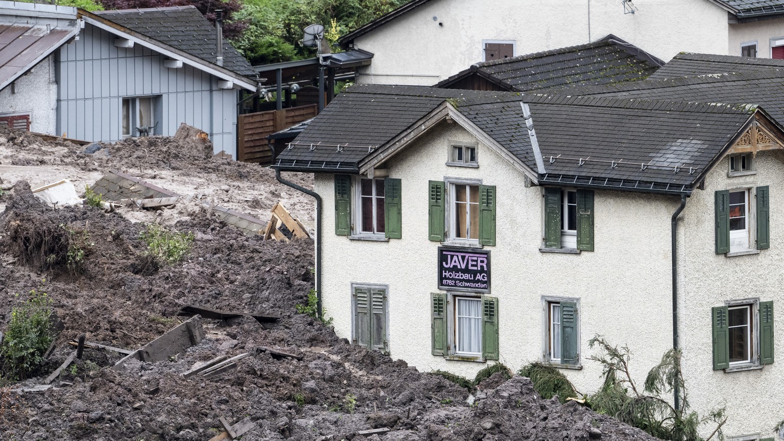 Geroell- und Schlammassen verdecken Haeuser in Schwanden, aufgenommen am Mittwoch, 30. August 2023. Wie die Kantonspolizei am Vorabend mitteilt, zieht sich der Erdrutsch auf eine Laenge von rund 400 M ...