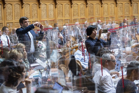 Min Li Marti, SP-ZH, rechts, und Jon Pult, SP-GR, fotografieren das Abstimmungsergebnis nach der Debatte um die Medienfoerderung, an der Herbstsession der Eidgenoessischen Raete, am Donnerstag, 10. Se ...